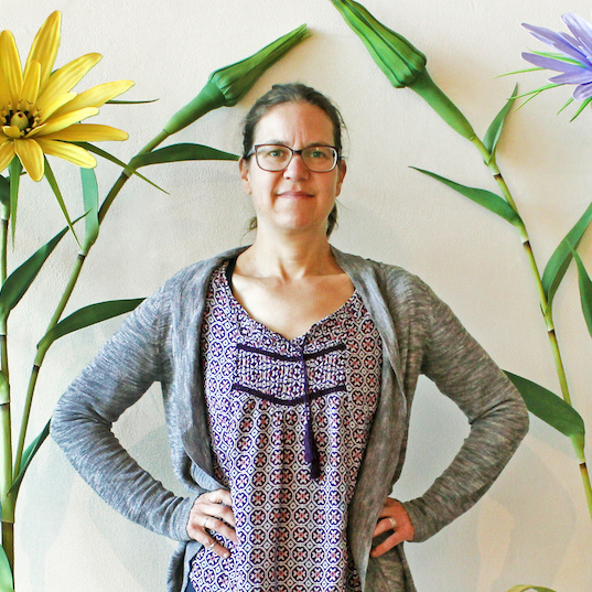 Renee Adams in front of a flower mural